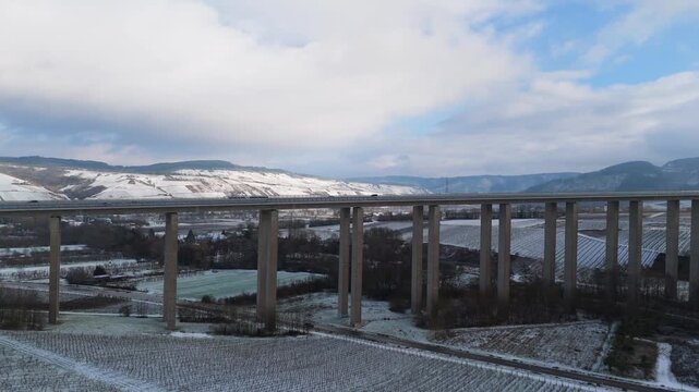 Moselle vineyard, Viaduct Longuich, Mosel valley, snow in winter season, bridge of highway crossing river near Trier, aerial view