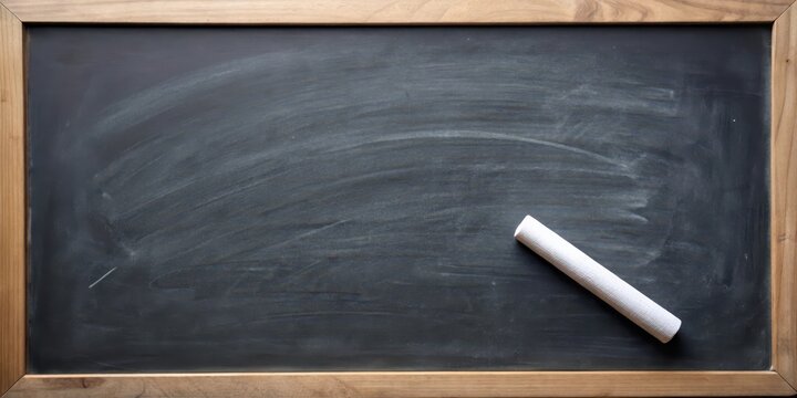 White chalk stick stuck on a blackboard with a few scattered chalk marks around it