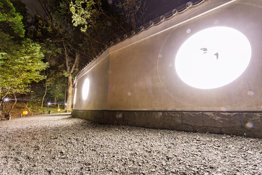 Bright circular light projections on a traditional white wall at Koishikawa Korakuen Garden at night January 2024