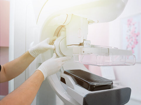 Technician installing compression paddle on mammography machine