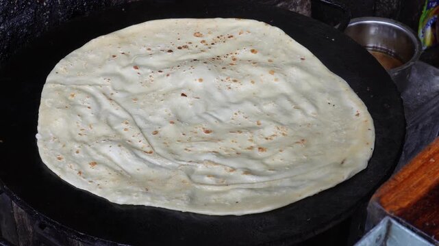 Flatbread cooking on hot iron tawa