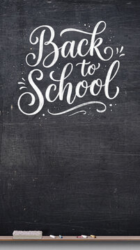 A blackboard with the words "Back to School" written in decorative chalk calligraphy and a few pieces of chalk and an eraser.