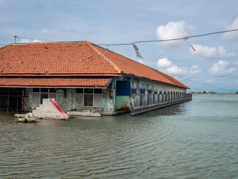 Flooded Abandoned School Building in Coastal Village with a very wide area of sea water

