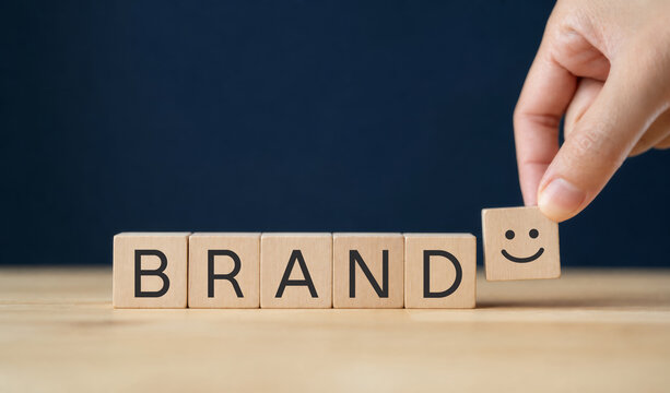 Emotional Branding and Happiness. Placing smiling wooden cube next to blocks spelling Brand. Emotional branding, customer happiness, positive experience and building meaningful brand connections.
