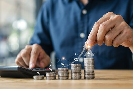 Business professional stacking coins on financial documents. Male executive analyzing investment growth with calculator and savings.