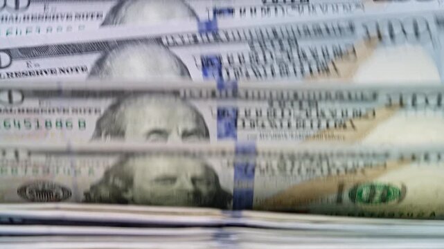 Automatic cash counting machine counting 100 dollar bills. Visual concept of financial success, business growth, investment, wealth accumulation and economic activity.