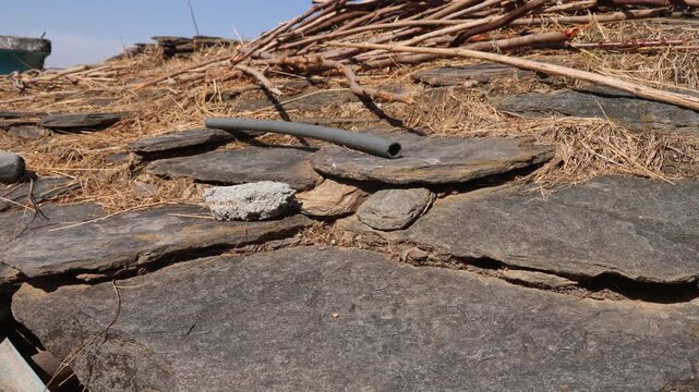 Raw video footage of a traditional stone roof on an old village house in rural India, showcasing vernacular architecture and rustic countryside construction.