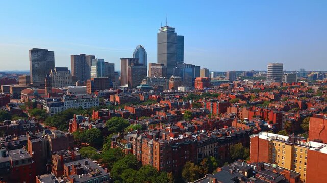 Red-brick historic apartment blocks in the green Back Bay neighborhood. High-rise buildings in the backdrop. Boston, Massachusetts, USA.
