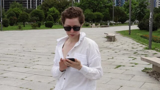 middle aged woman checks a mobile health app in a public park, representing telehealth, treatment follow up and technology supported cancer survivorship