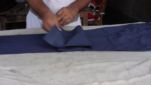 Traditional iron pressing blue fabric with care
