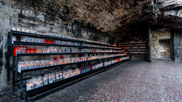 Votive candles illuminated in a barrel-vaulted niche