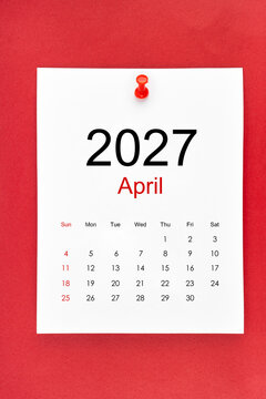 April 2027 calendar page with push pin on red color background.