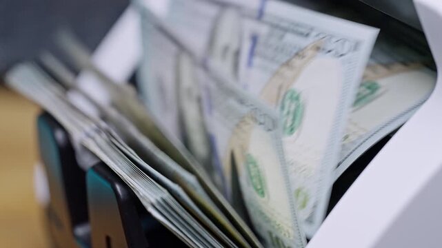 Automatic banknote counter verifies US dollar bills during counterfeit detection. Secure cash processing, authenticity verification, banking technology and financial security.