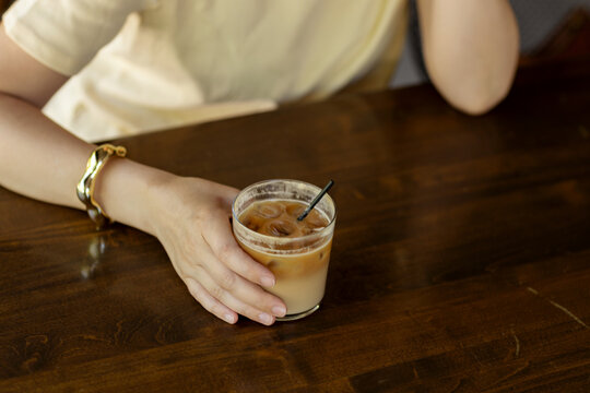 Woman enjoying iced coffee in a cozy cafe