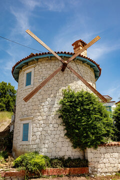 Rustic stone windmill against a clear blue sky