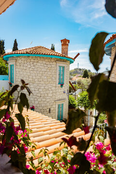 Charming stone house with red roof and blue accents