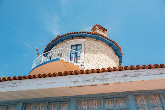 Round stone house with balcony under blue sky