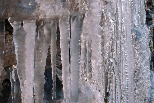 Close up of shimmering icicle wall on frozen rock face