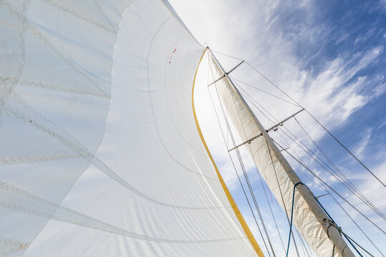 Sailboat mast and sail under clear sky