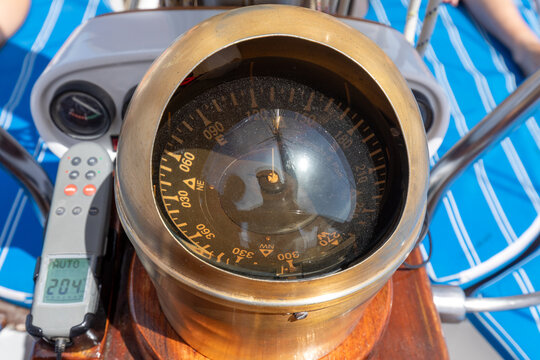 Navigation compass on a sailboat helm in the sun