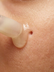 Fototapeta premium Moisturizing serum droplet applied to skin, enhancing hydration and glow