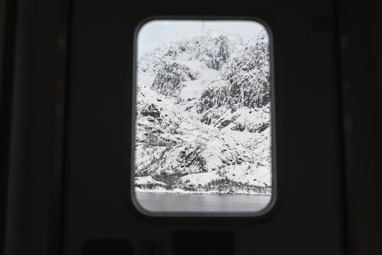 Snowy mountain view through a window frame