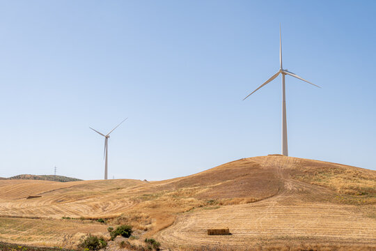Wind turbines on Spanish hill under blue sky