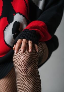 Woman wearing black fishnet stockings and red leather jacket posing
