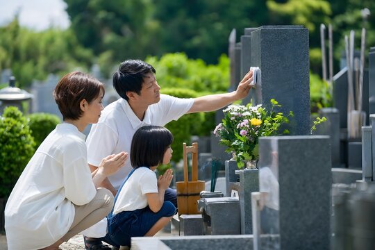 お盆に墓参りをする家族