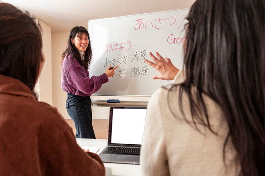 Adult Japanese lesson with teacher at whiteboard in class