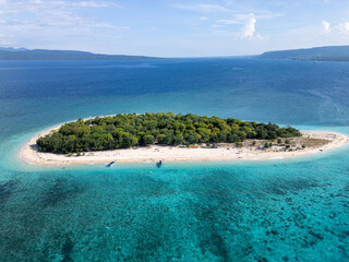 Wide Aerial Drone View of tropical island featuring crystal clear turquoise water, white sandy beaches and tropical trees. Tabuhan Island in East Java, Indonesia © Phil B