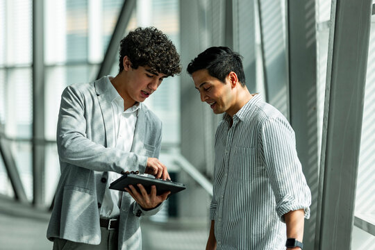 Business colleagues reviewing data on a tablet in office