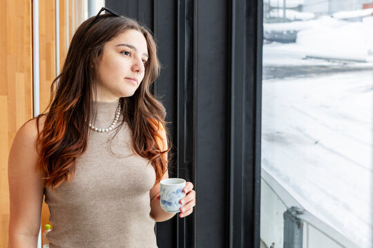 Student coffee break by window in cozy cafe, portrait