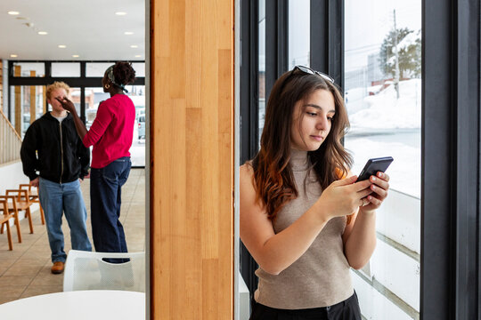 Young college student using smartphone during campus break