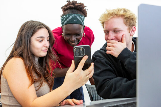 Multiethnic student group sharing smartphone during study