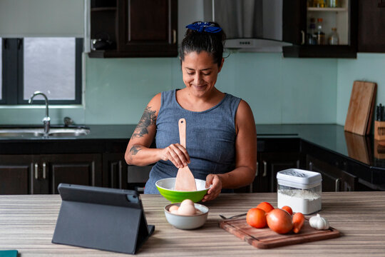 Woman cooking handmade pasta dough in modern kitchen at home