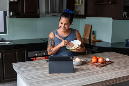 Woman preparing handmade pasta while following an online recipe