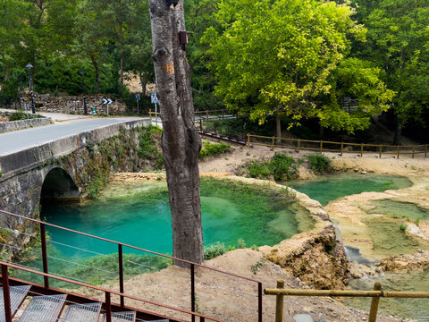 peaceful spring stillness in a park-like environment with concrete bridge and wooden railings viewed, Risco los camellos, Cascada de Orbaneja del Castillo 
