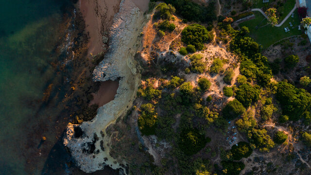 serene aerial view of rocky coastline with sand and vegetation in a natural setting above the beach and coastal area with a clean background and copy space for travel Praia dos Aveiros