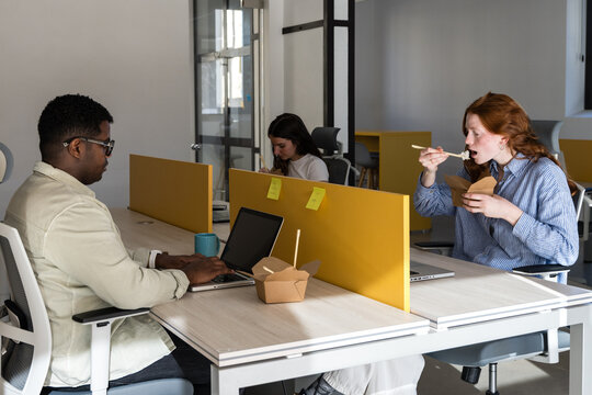 Coworkers working in modern open office during lunch break