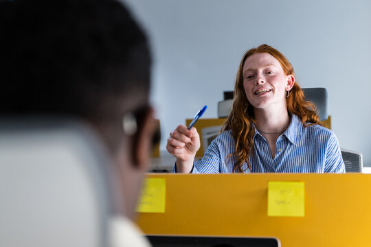 Employee giving feedback during office meeting with colleague