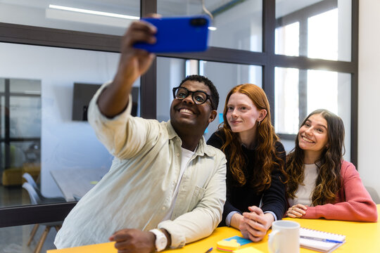 Diverse colleagues taking a selfie in a modern office