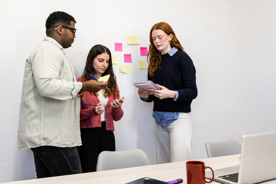 Team planning meeting with sticky notes and notebook