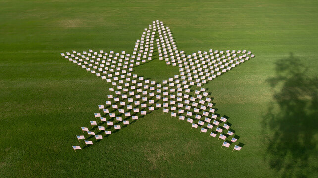 Aerial drone photo of star-shaped flag display on grass lawn