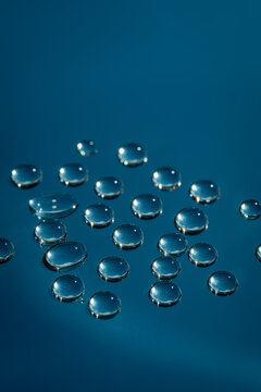 Macro water drops on glass with blue abstract backdrop