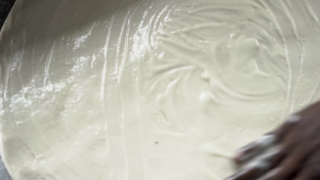 Skilled hands shaping layered dough for authentic laccha paratha preparation.
