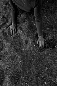 Hands on sand in black and white minimal composition