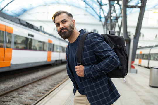 Indian commuter with backpack waiting on railway platform
