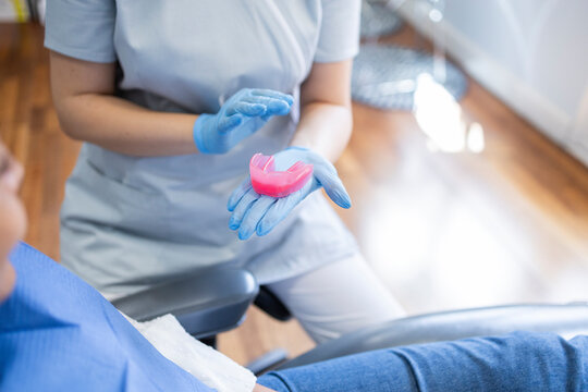 Dental professional explaining mouthguard to patient