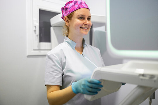 Dentist in professional attire working in a clinic setting